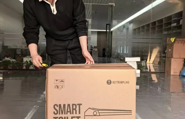 Smart toilet product packed in a cardboard shipping box.